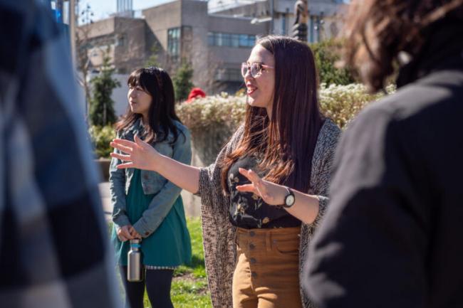 Tour guide speaking to students outside on a sunny day