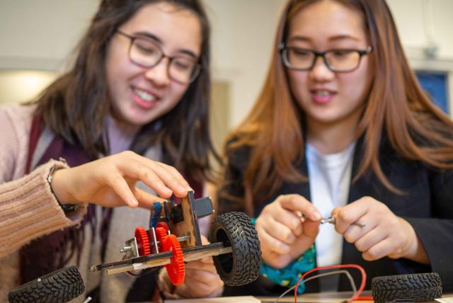 Students working with hands-on machines in class.