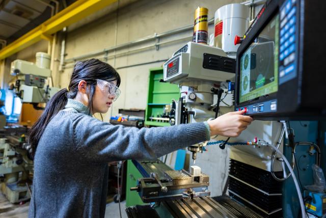 Female student working in a machine shop