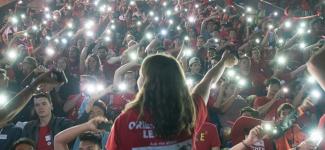 A gathering of UBC students using their mobile phones to light up a large auditorium.