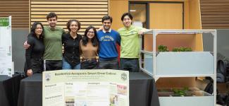Student taking a group photo with their project