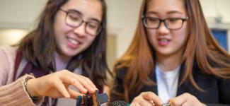 Students working with hands-on machines in class.
