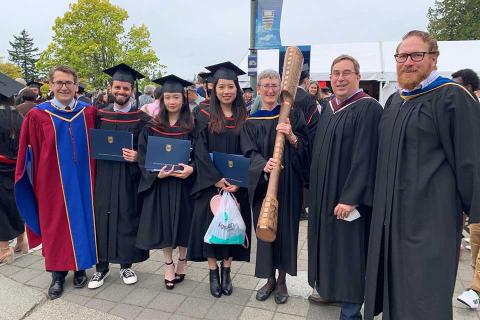 Graduates with the dean and MANU director and faculty